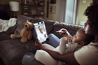 Mom and baby doing a virtual visit with doctor on iPad