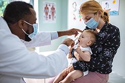 Mom holding baby for flu vaccine