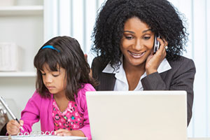 Mom on phone at laptop with daughter