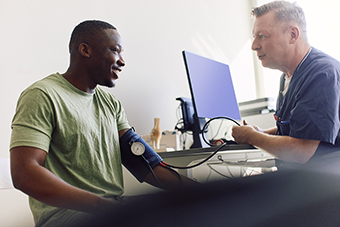 Young adult male getting his blood pressure checked with a doctor